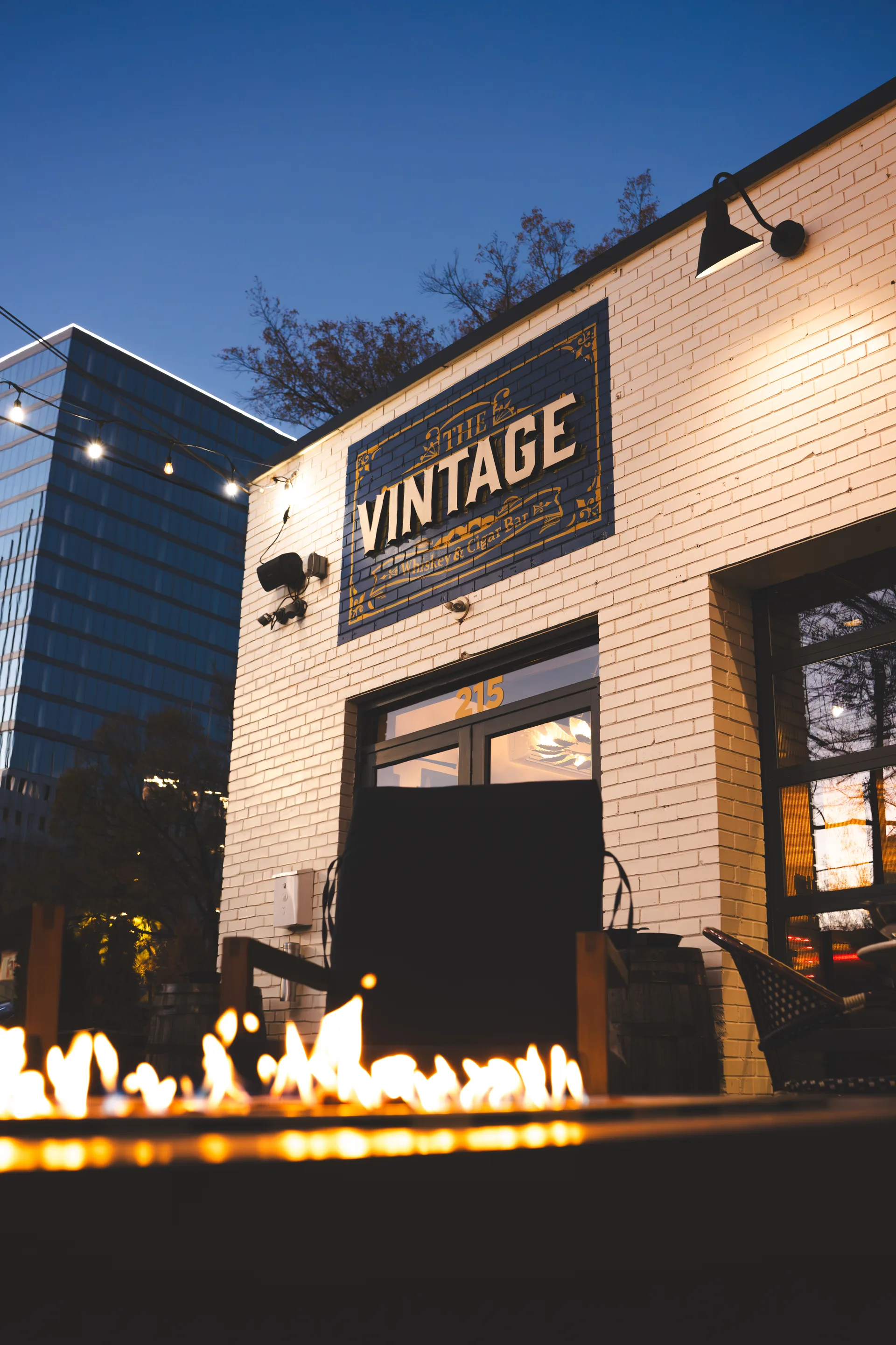 The Vintage exterior at dusk with the fire feature glowing in front