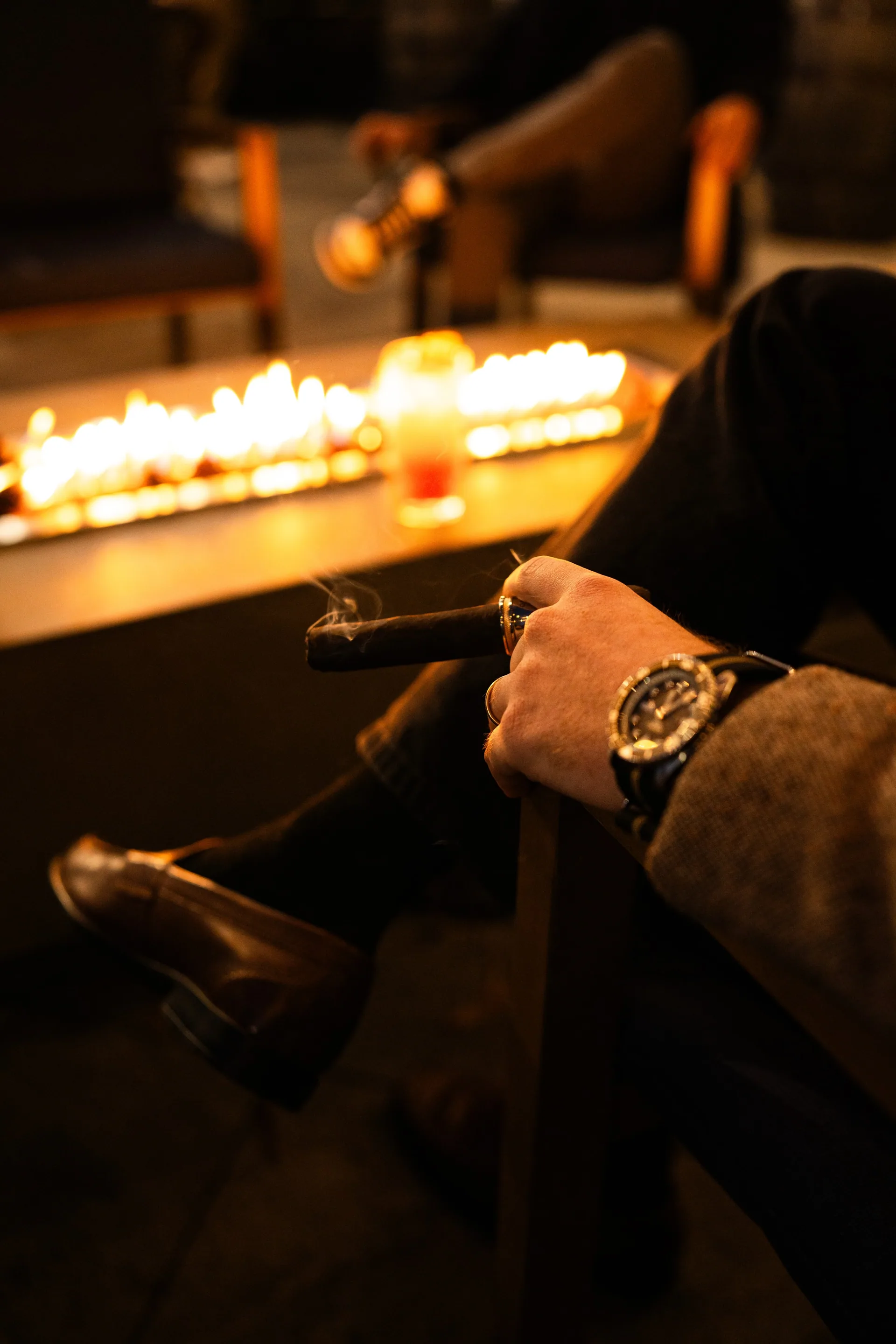 A guest enjoying a cigar beside the patio fire at The Vintage