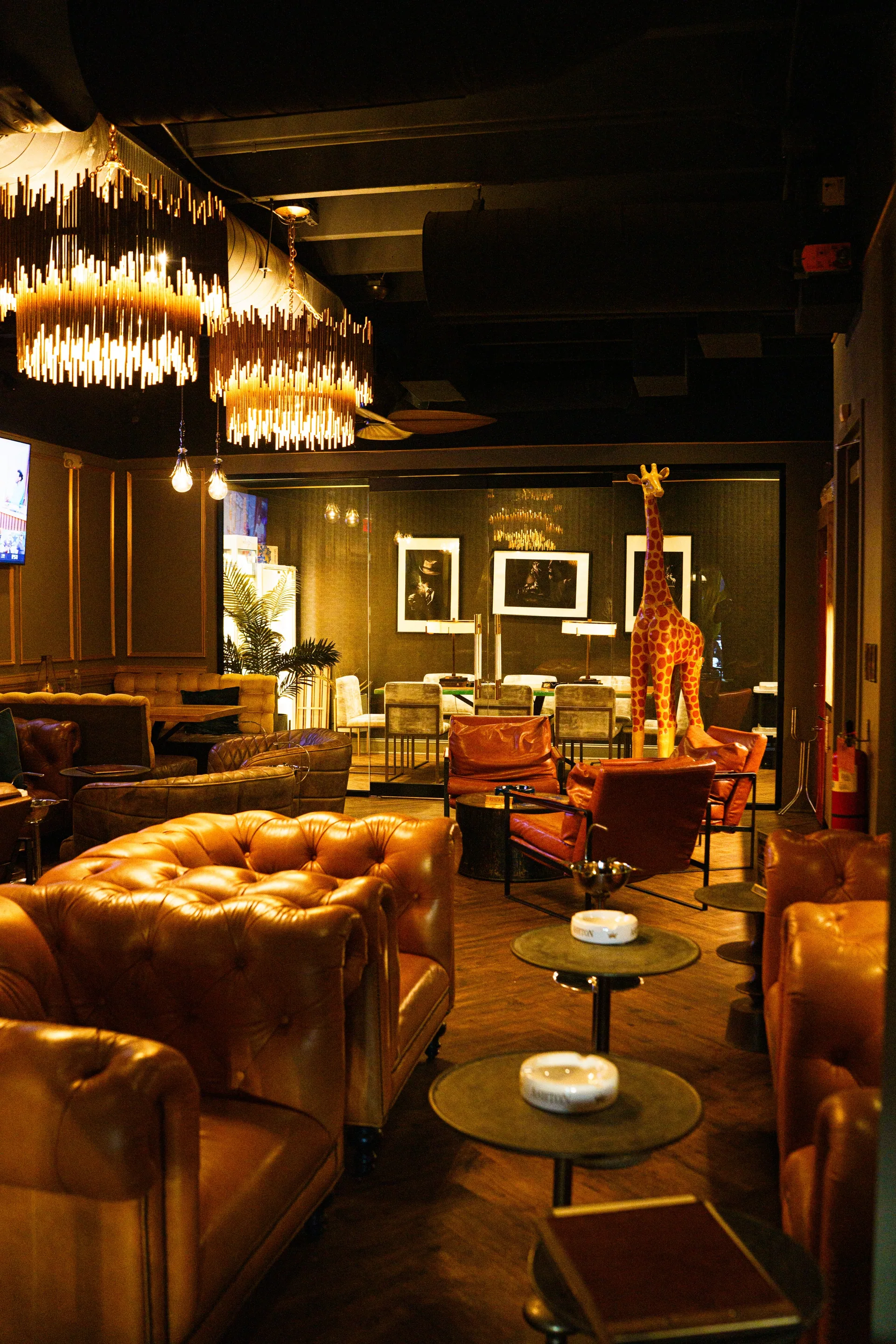 Leather lounge chairs and glowing chandeliers at The Vintage in golden afternoon light