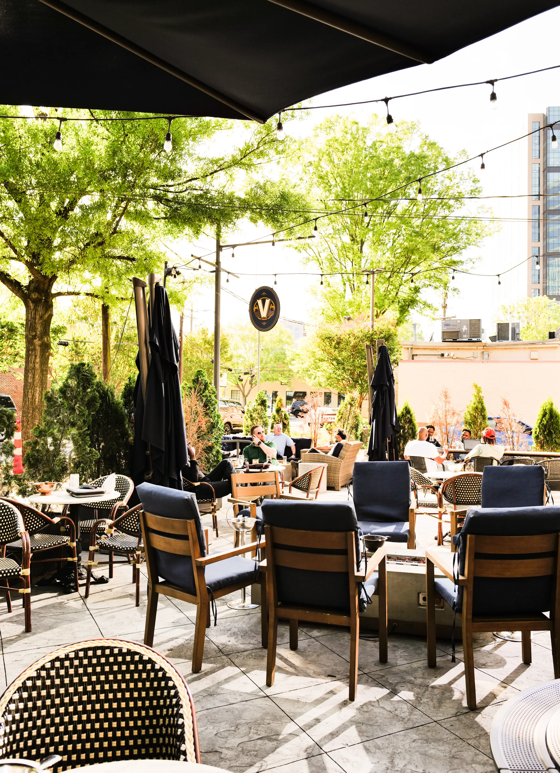 Guests gathering on The Vintage patio beneath trees and string lights